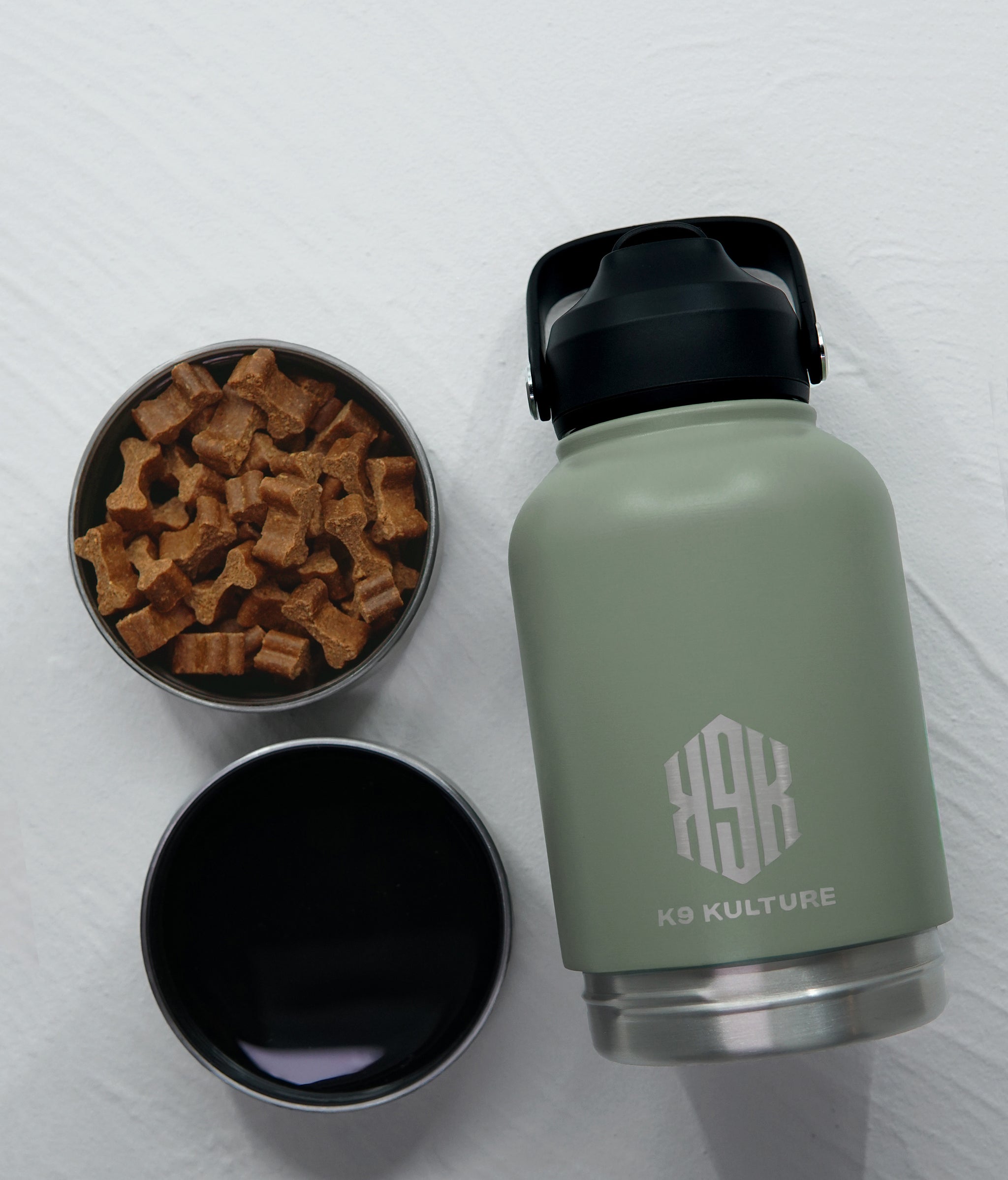 Green ThermoACTIVE insulated dog water bottle displayed with dual compartments—one filled with water, one with treats.