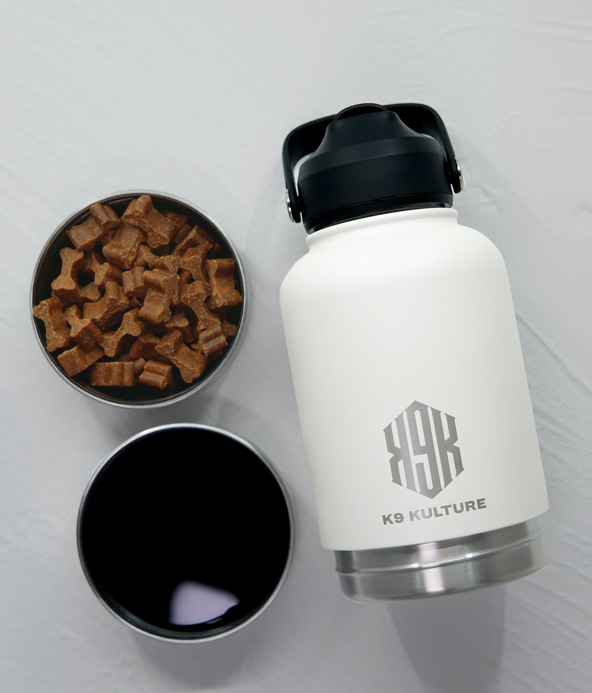 Off White ThermoACTIVE insulated dog water bottle displayed with dual compartments—one filled with water, one with treats.